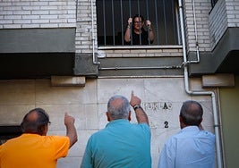 Vecinos de la Chana reunidos en la calle, justo debajo de una de las ventanas que ha sido sustraídas.