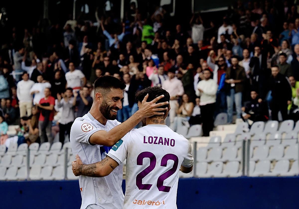 Mario Martos y Óscar Lozano celebran un gol con la afición blanca detrás