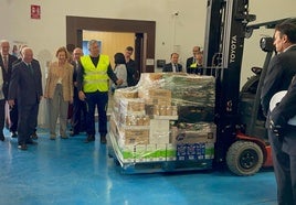 La reina emérita observa una demostración del traslado de un palet con alimentos a la furgoneta de la institución para el reparto.