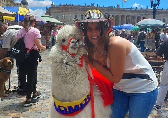 Marina Fernández, maestra de Educación infantil, junto a una alpaca, de la familia de las llamas, en la Plaza de Bolívar, en Bogotá.