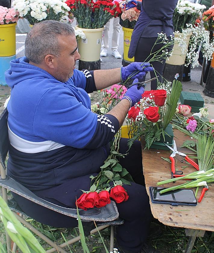 Imagen secundaria 2 - Varias familias colocando flores y un florista preparando un ramo
