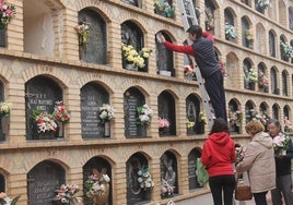 Operario limpiando una lápida en el cementerio de San Fernando