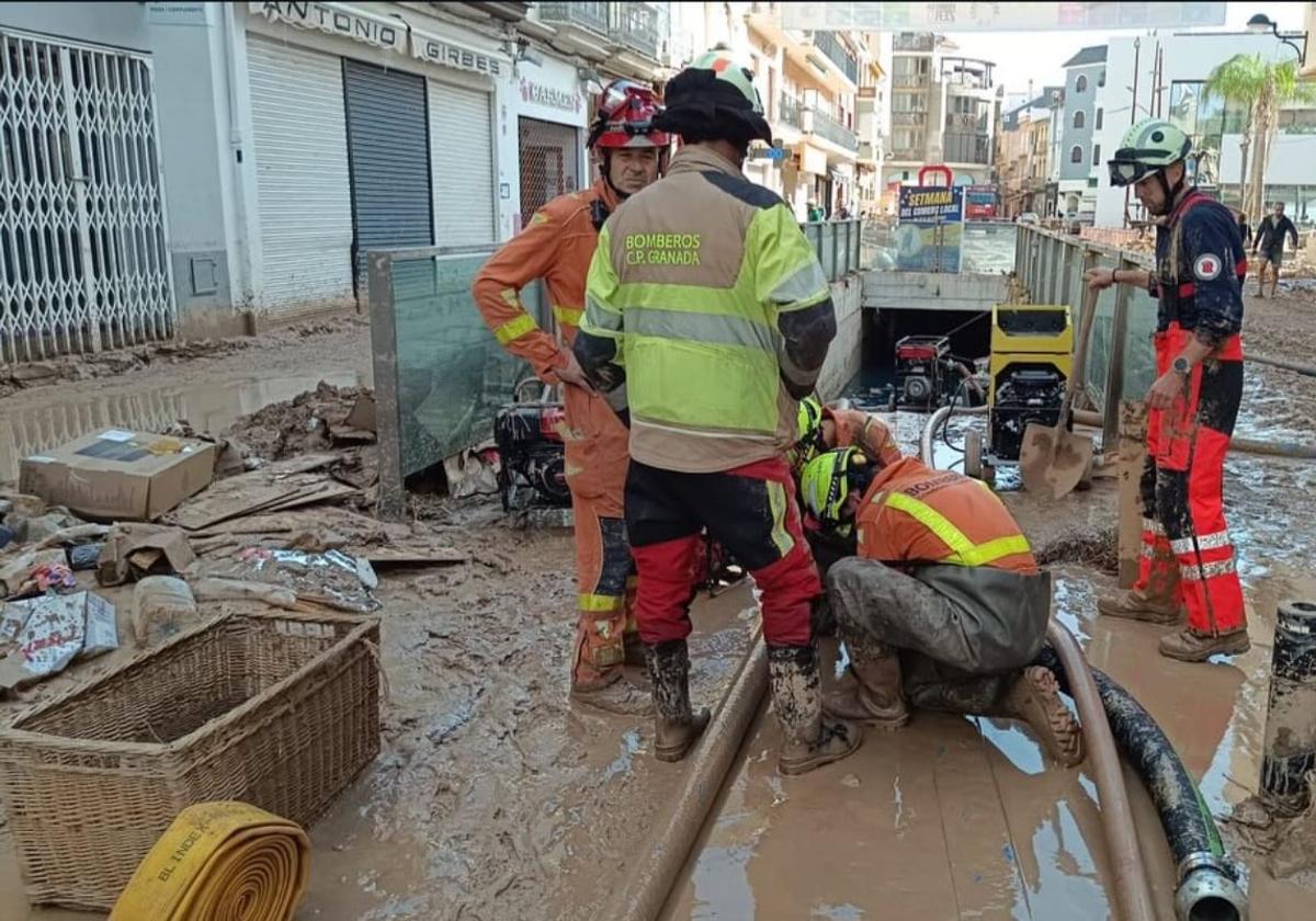 Bomberos de Granada evacuando agua de un garaje en la zona cero de la DANA.