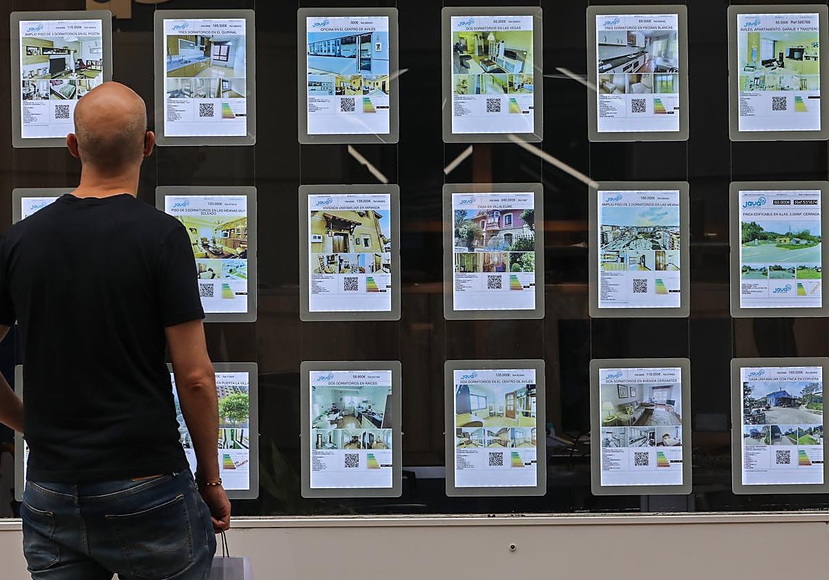 Un hombre observa los anuncios del escaparate de una agencia inmobiliaria.