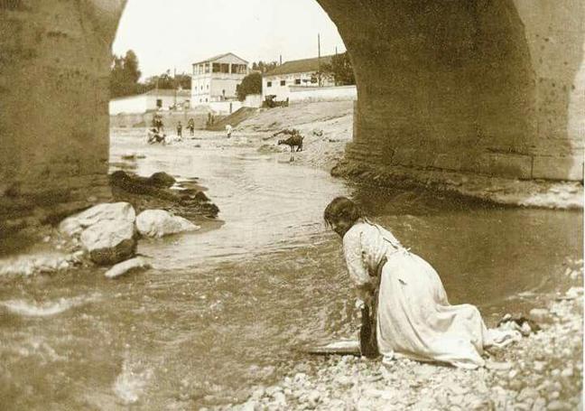 Lavandera bajo el Puente Romano a finales del siglo XIX.