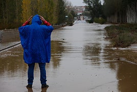 Un hombre se lleva las manos a la cabeza bajo la lluvia.
