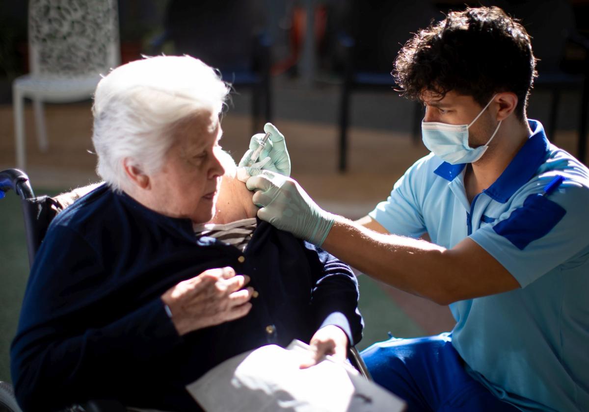 Una mujer se vacuna de la gripe en una residencia de mayores.