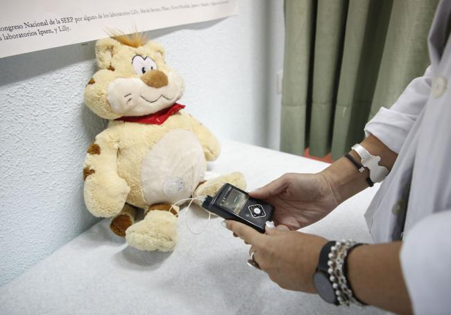 Una sanitaria maneja una bomba de insulina en una consulta pediátrica.