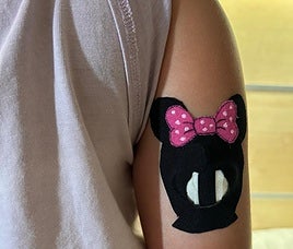 Una niña con un sensor de glucosa en el brazo.