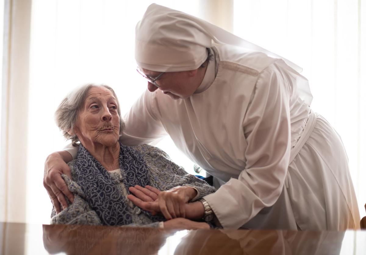 Una de las hermanitas con una residente.