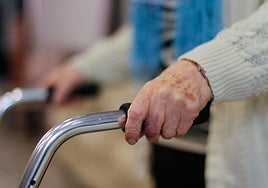 Una anciana camina con la ayuda de un andador.