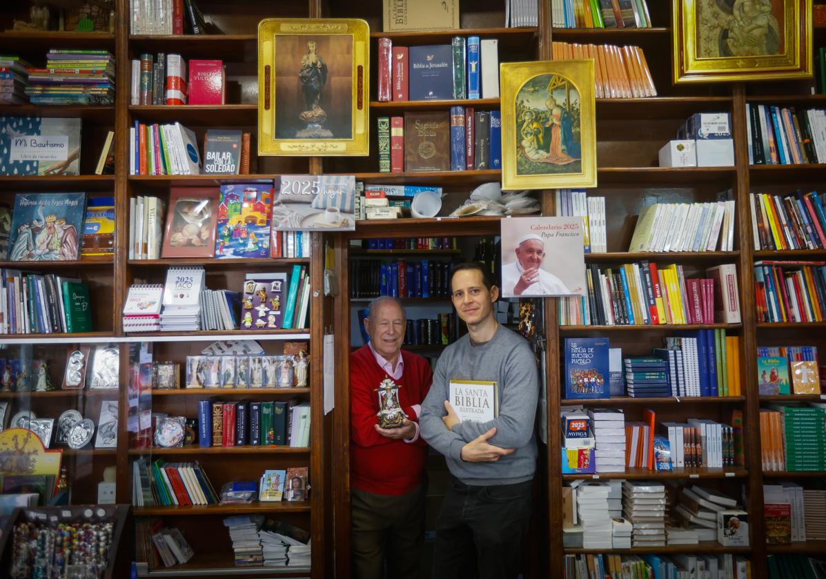 José Manuel, a la izquierda, y su hijo Javier, a la derecha, posan en el interior de de la librería El Sagrado Corazón