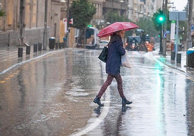 Una mujer camina por el Centro de Granada con un paraguas, en la jornada de DANA del pasado miércoles.