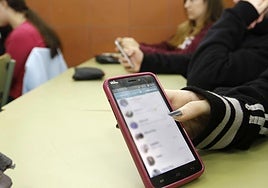 Una joven muestra su guasap.