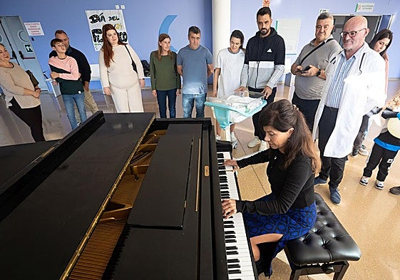 Marian Munilla, en el piano, y el doctor Diego Fernández, con pacientes de la planta de Pediatría.