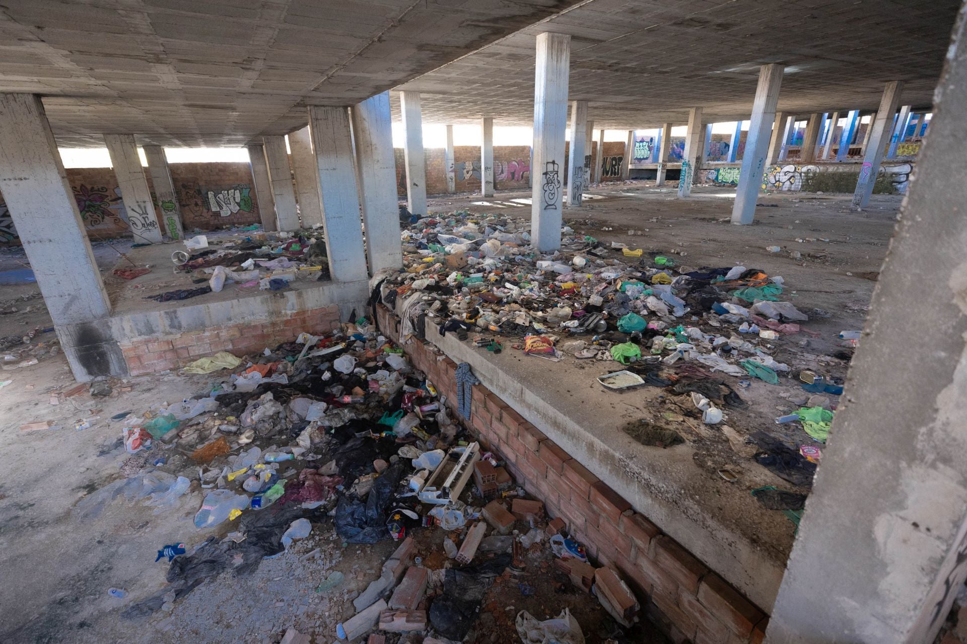 Basura acumulada en una de las plantas subterráneas del esqueleto de la antigua ciudad deportiva.