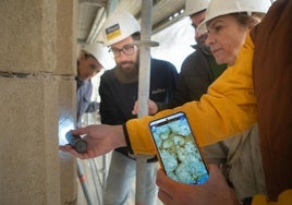 Observando con un microscopio uno de los fósiles aparecidos en la torre, a unos cuarenta y cinco metros de altura.