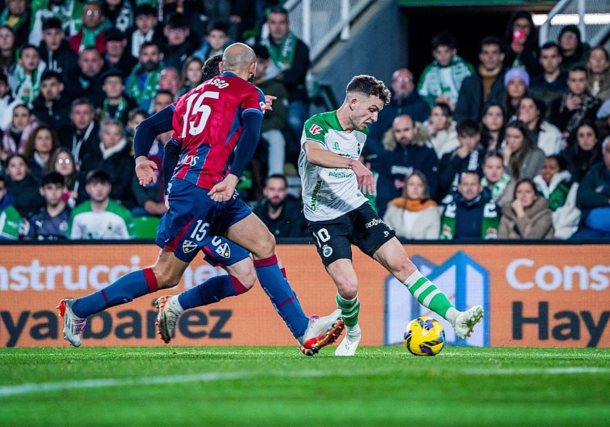 Los futbolistas del Huesca defienden un pase de Iñigo Vicente.