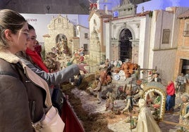 Dos jóvenes visitan el belén napolitano de la Fundación Caja Rural de Jaén bajo la lonja de la Catedral.