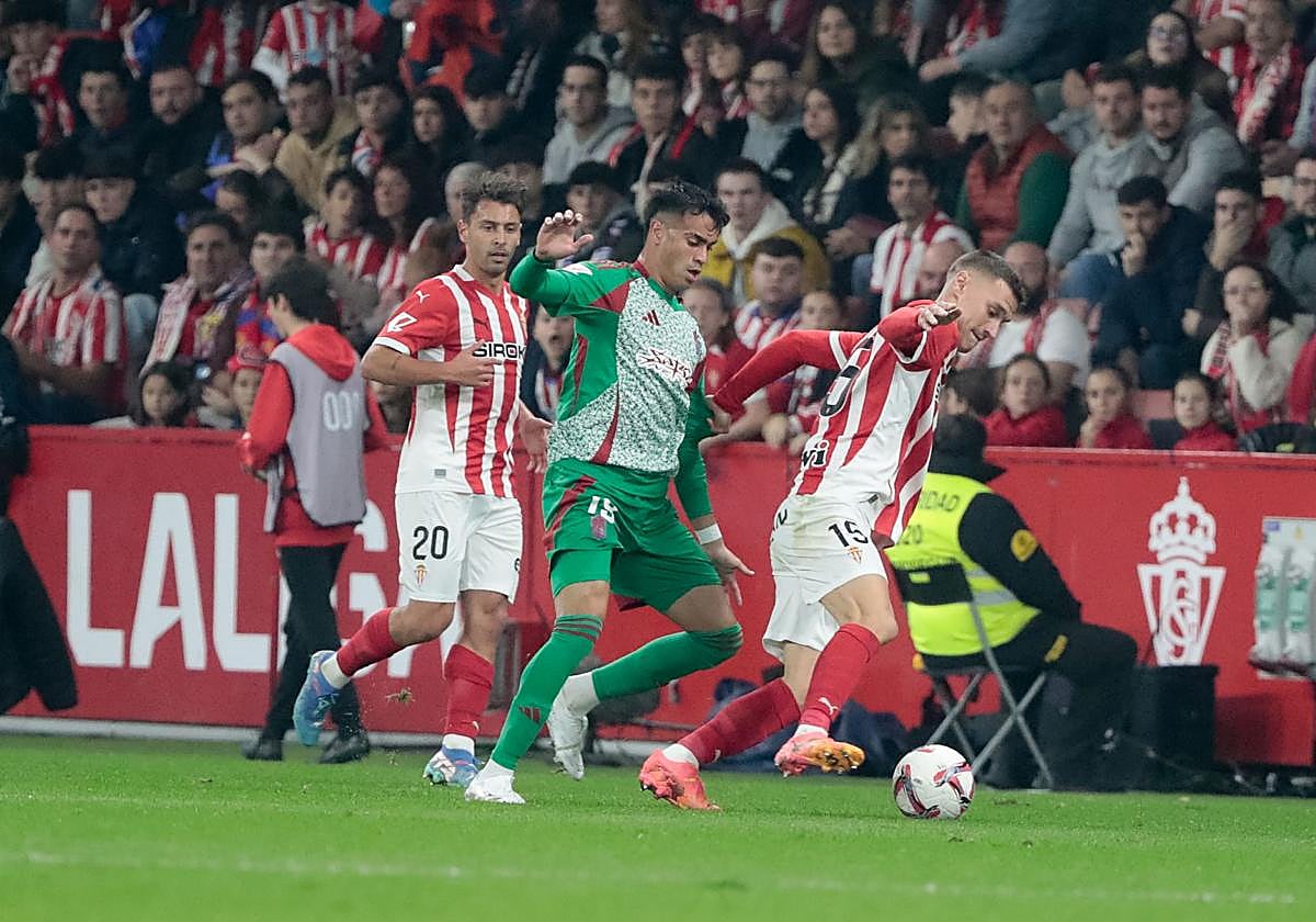 El granadinista Reinier persigue a un rival del Sporting en El Molinón este curso.