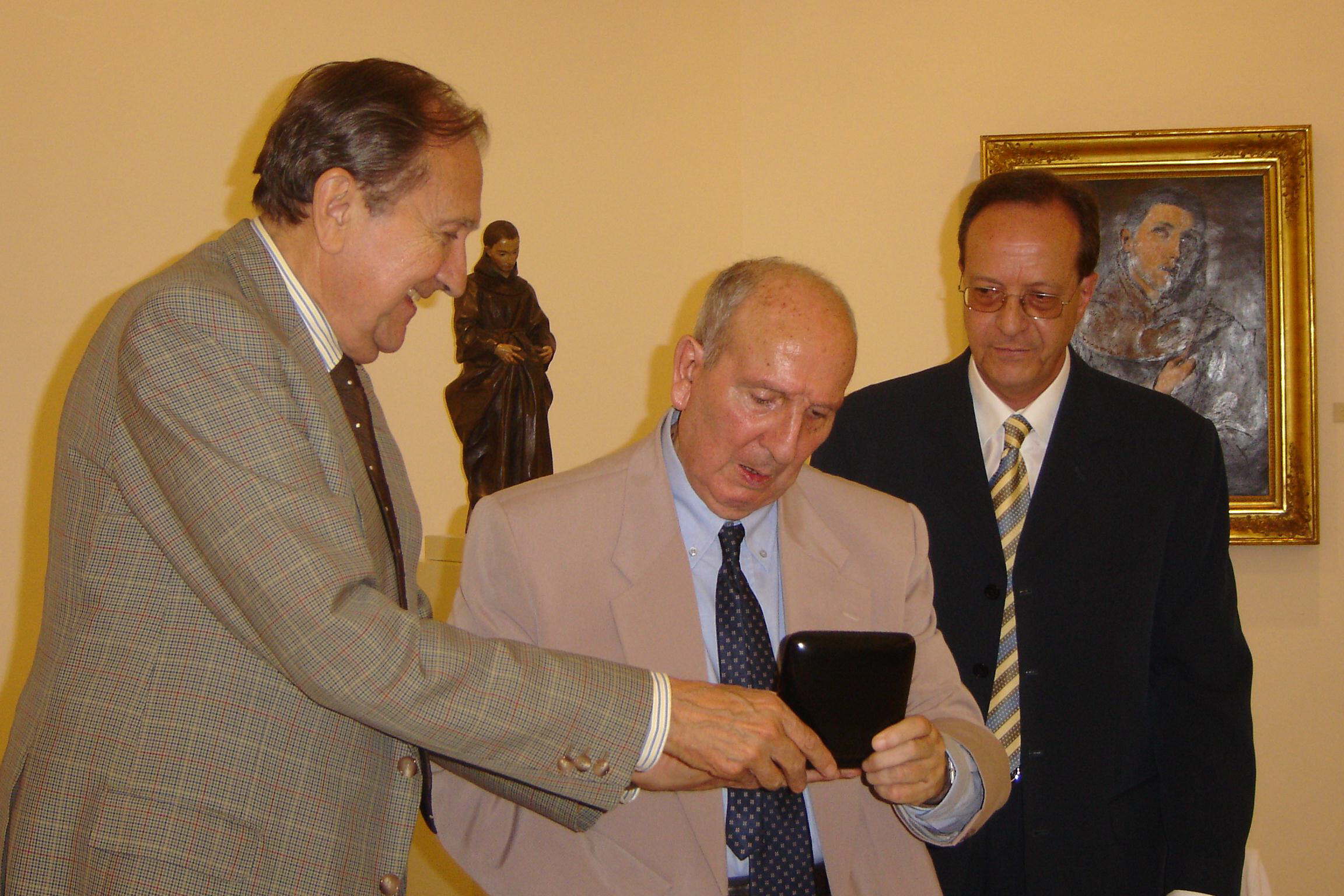 El dramaturgo, José Martín Recuerda, en el centro, recibe la Medalla de Honor de la Fundación Rodríguez-Acosta de manos de su presidente, el pintor, Miguel Rodríguez-Acosta. Año 2004