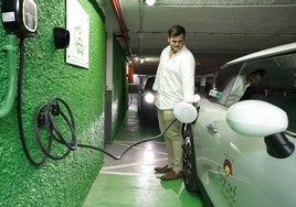 Un usuario recarga su coche eléctrico en un parking.