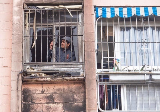 Julio César observa el cristal roto de su ventana un día después del incendio.