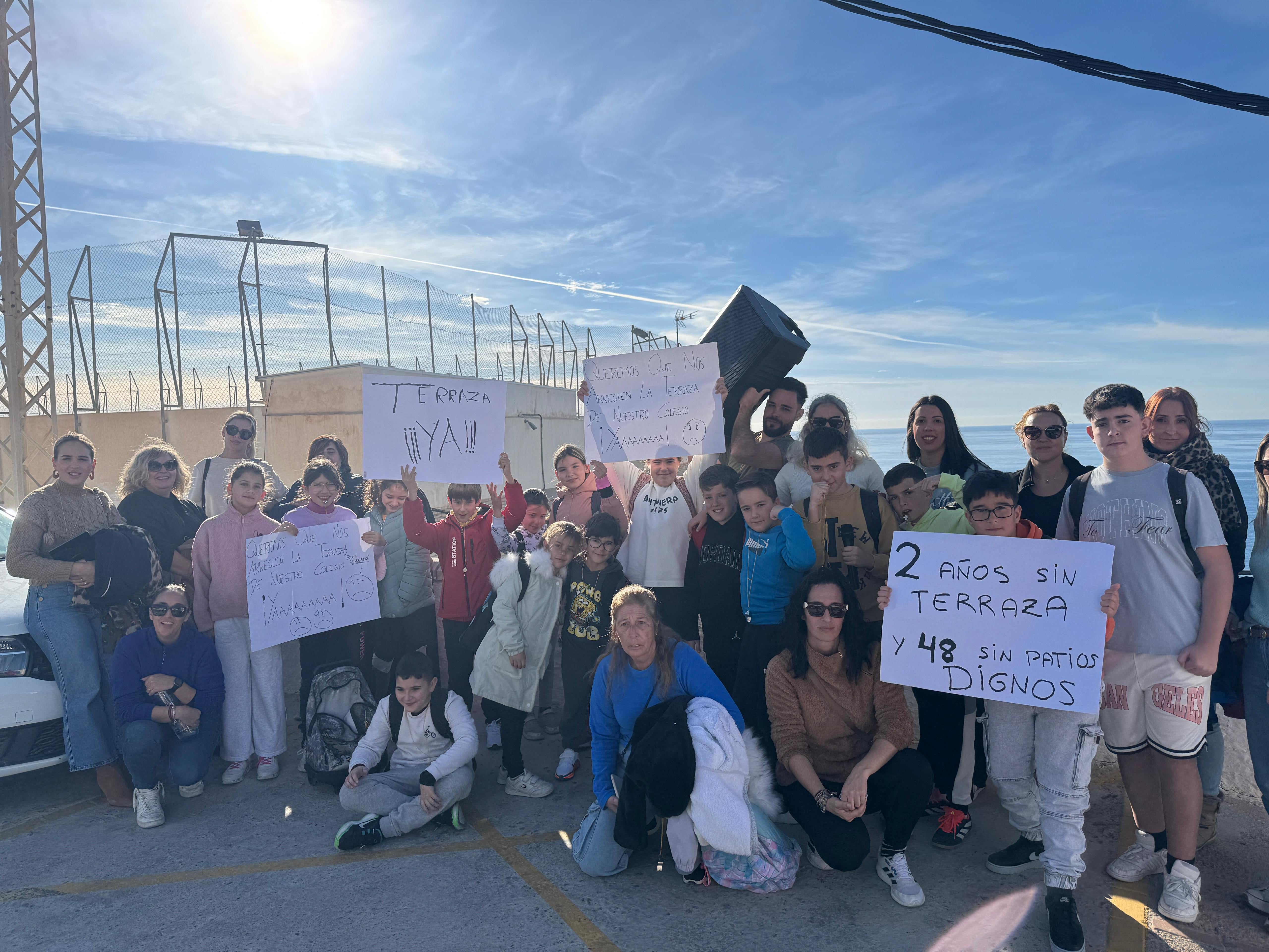 Los niños y padres del colegio de La Rábita con las pancartas en la manifestación, ayer.