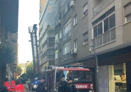 Un bombero intenta acceder al interior de la vivienda incendiada.