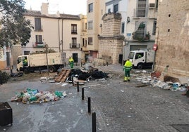 Operarios de FCC limpiando los restos de la lumbre de la plaza de La Merced.