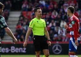 El colegiado Muñiz Muñoz explica a Brau su infracción en el penalti para el Sporting.