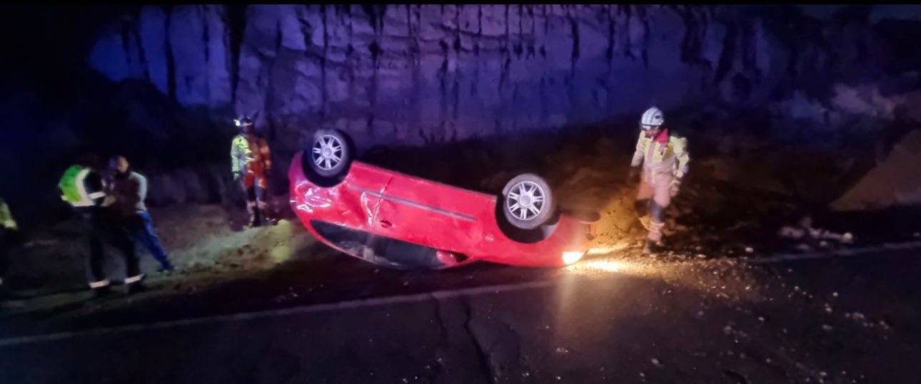 Los rescatadores observan el coche siniestrado.