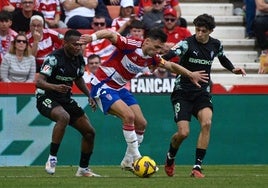 Lucas Boyé protege un balón entre dos futbolistas del Sporting.