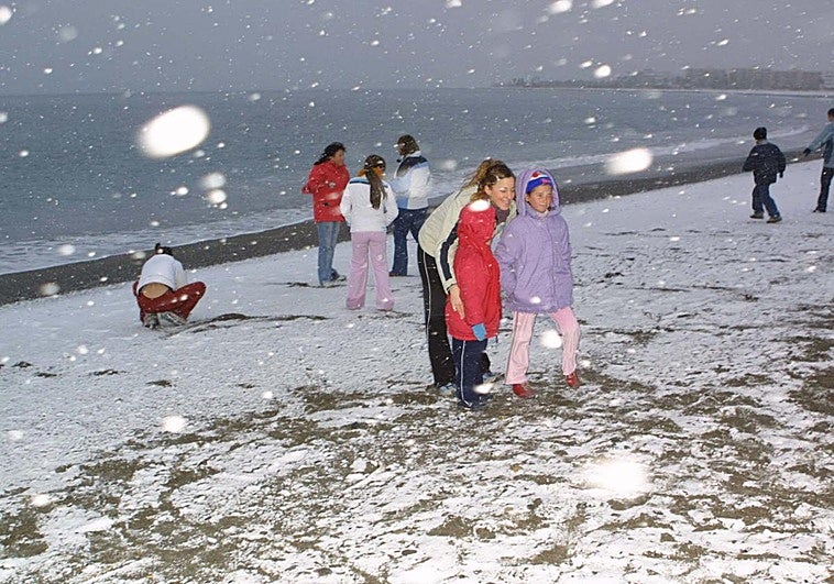 Niños juegan con la nieve en la Playa de Poniente
