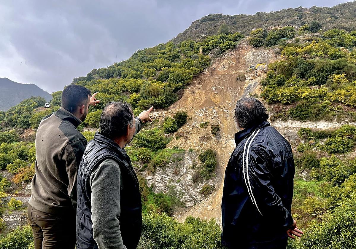 Vecinos señalando el derrumbe donde trabajan las máquinas.