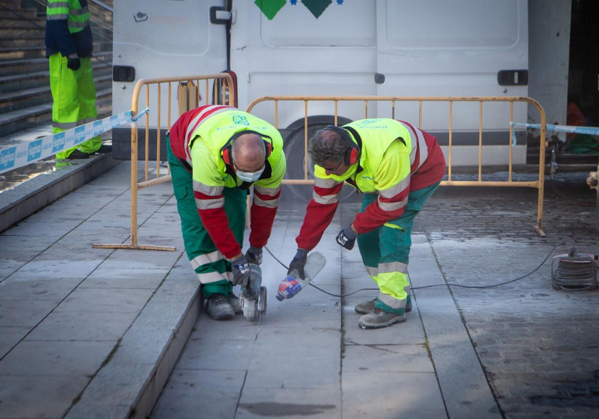 Imagen principal - Arriba, arreglando el piso. Abajo, trabajo en los jardines de la rotonda y revisión de semáforos. 