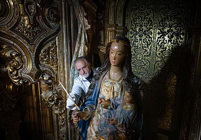 Dionisio Olgoso quita el polvo a la talla de la Virgen.