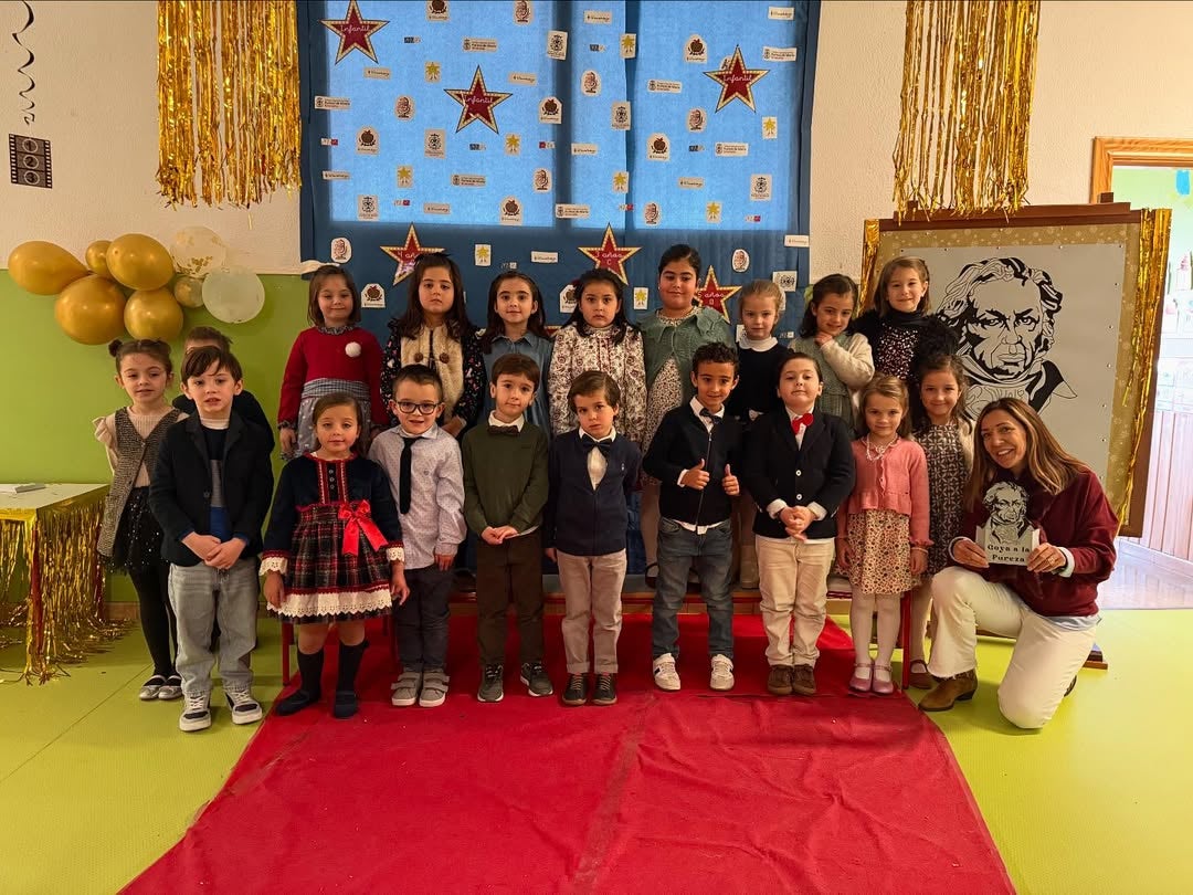 Imagen principal - Algunas de las clases posando en la alfombra y vista del pasillo decorado con la alfombra.