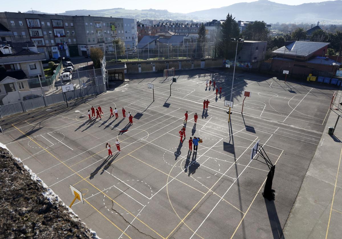 Foto de archivo de unos jóvenes jugando a baloncesto en unas pistas deportivas.