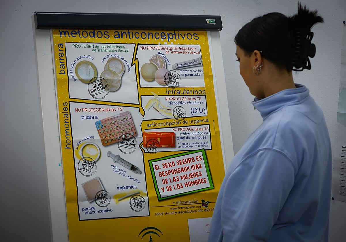 Una joven observa un cartel sobre sexo seguro en el centro de orientación juvenil de la UGR.