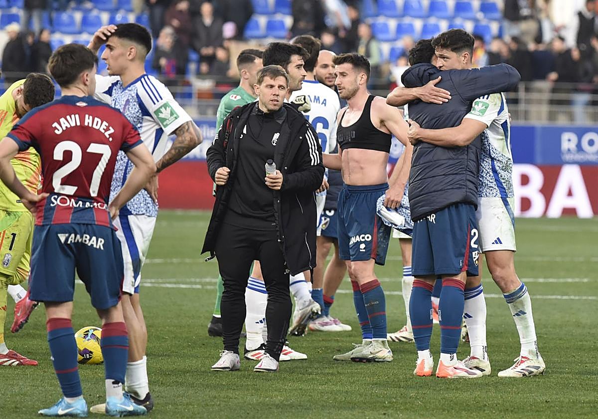 Miguel Rubio abraza a un excompañero en el Huesca tras el partido.