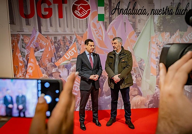 El presidente de la Junta de Andalucía, Juanma Moreno junto all secretario de UGT Andalucía, Oskar Martín.