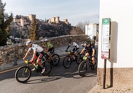 Corredores cruzan el barrio del Sacromoente con la Ahambra al fondo en la segunda etapa disputada en Granada.