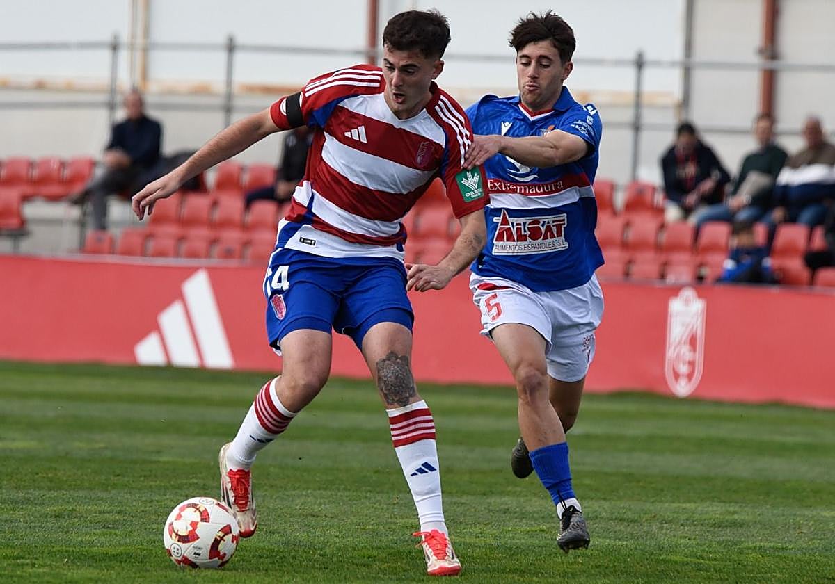 Iker Burgos conduce un balón perseguido por un rival.