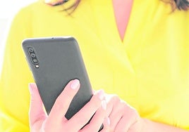 Una mujer llama por teléfono con su móvil.