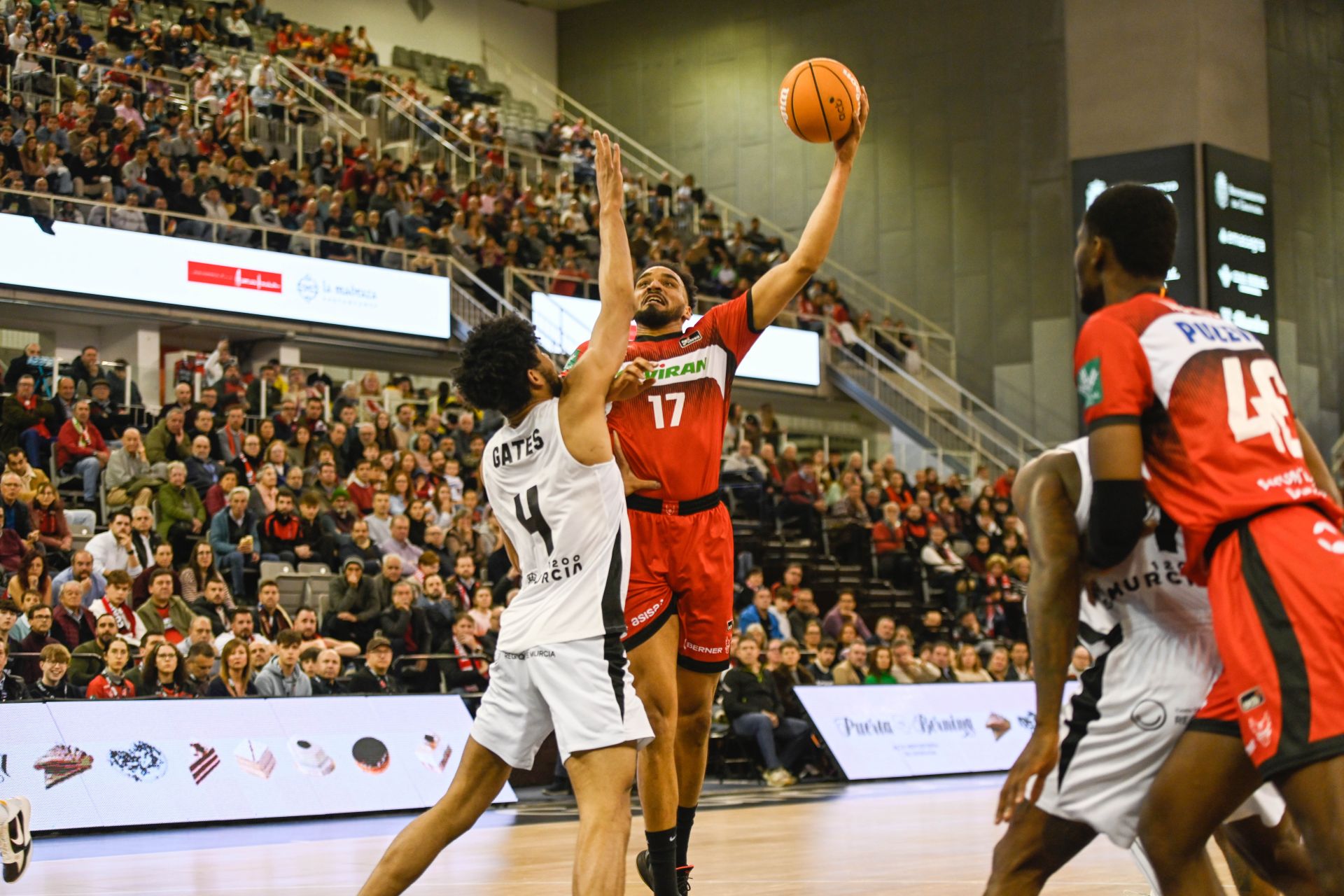 Amine Noua busca el enceste en el poste bajo frente a Gates, en presencia de Ousmane Ndiaye.