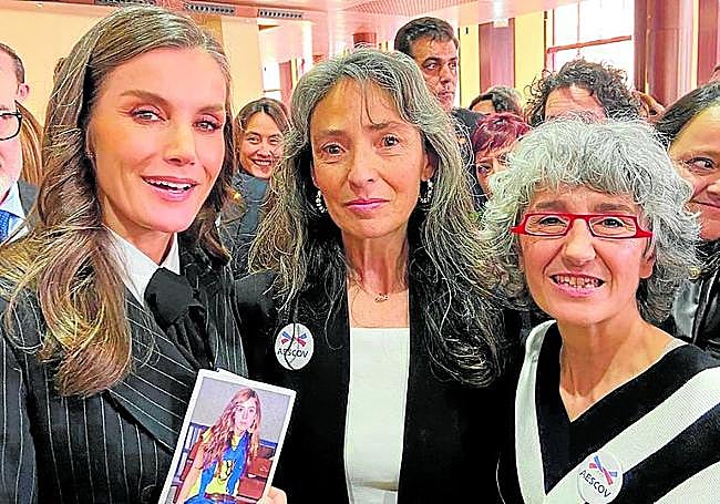 La Reina, con la foto de Teresa, junto a la madre y una socia de AESCOV.