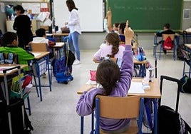 Una alumna pregunta a la docente en un aula de Primaria.
