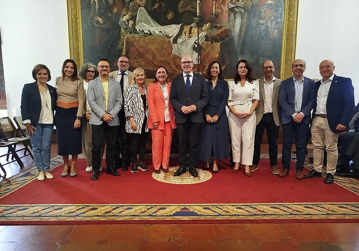 Mónica López, traje naranja, con rector, vicerrectores, secretaria general y gerente.