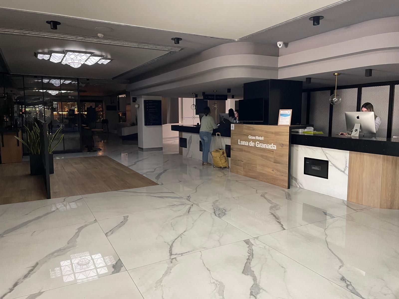 Dos turistas en la recepción del Gran Hotel Luna de Granada.